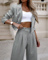 Gestreept tweedelig damespak in lichtgrijs, gedragen met crop top