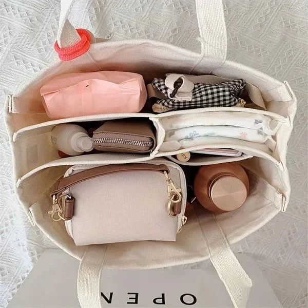 Beige canvas tote met stevige riemen en ruim hoofdvak.