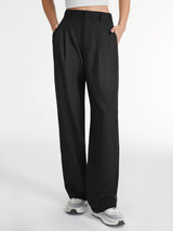 Model in grijze pantalon met witte tanktop
