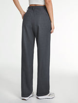 Model draagt grijze straight leg broek met wit topje
