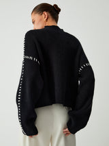 Zwarte gebreide sweater met mock neck van achteren
