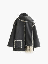 Zwarte cape met witte randen hangend