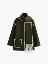 Groene cape met witte afwerking en sjaaldetail