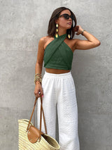 Groene crop top met crisscross halter en high-waist broek
