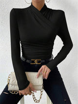Model in zwarte cross-over top en jeans
