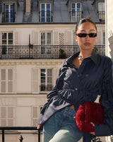 Navy blouse met elastisch detail, gedragen op terras
