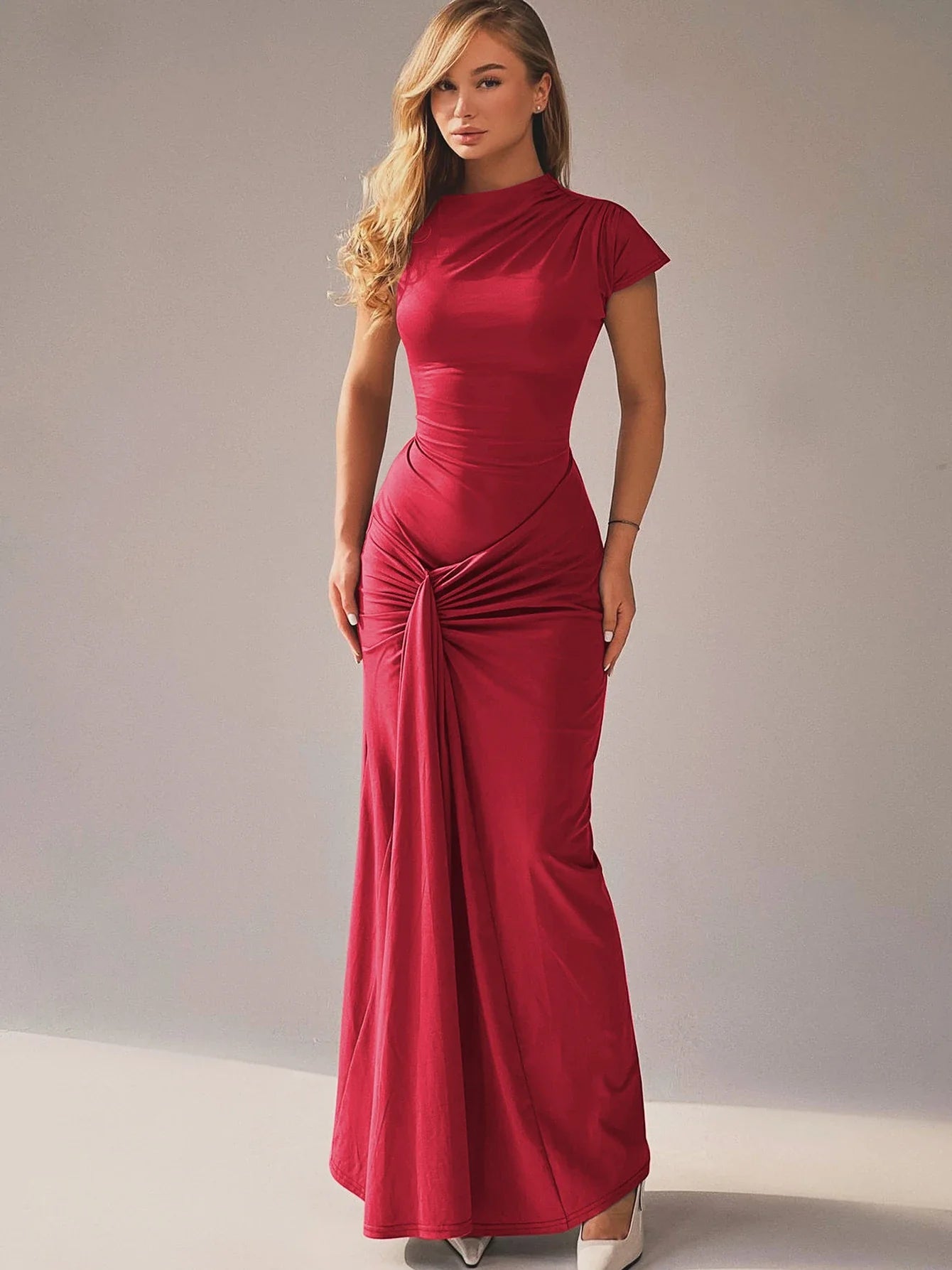 Model in de rode Celina Lace-Up Gown, elegante pasvorm en subtiele glans
