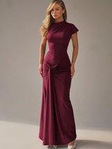 Model draait in de bordeauxrode Celina Lace-Up Gown met lace-up detail op de rug
