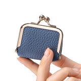 Donkerblauw leren miniportemonnee met gouden sluiting in hand