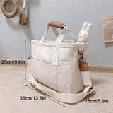 Beige canvas tote met stevige riemen en ruim hoofdvak.