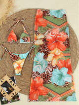 Bikini set met rok plat gelegd op strandmat met bloemenprint